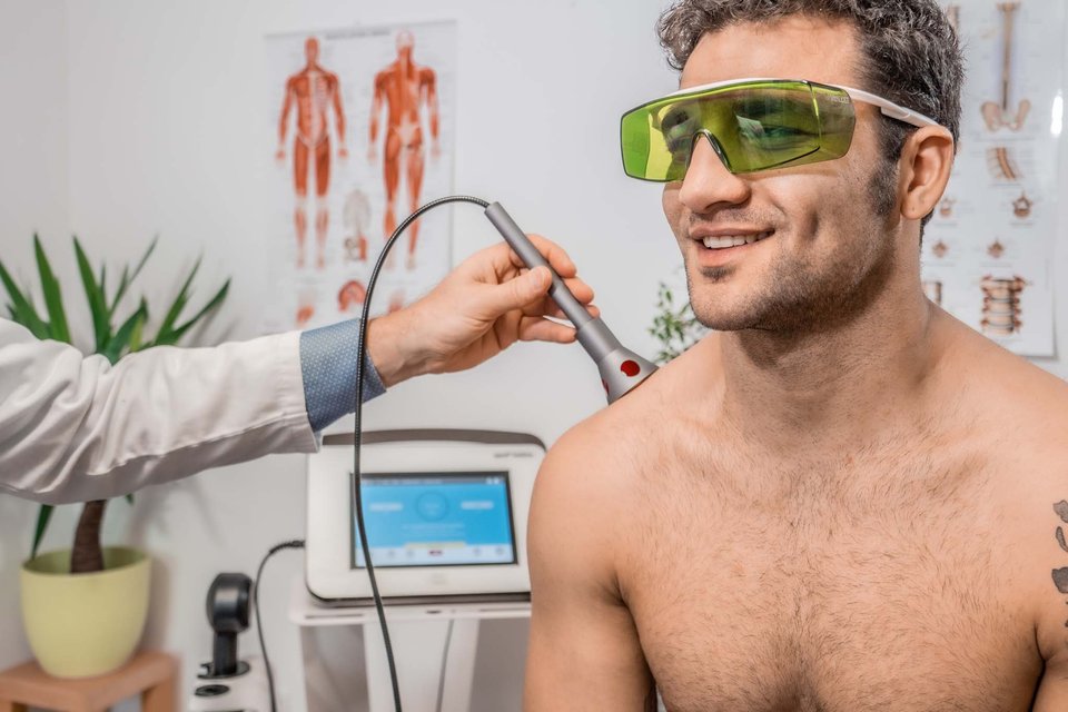Trattamento laserterapia QMD EOS Plus Studio Medico Lazio Roma Parioli — fisioterapista applica il laser ad alta potenza sulla spalla